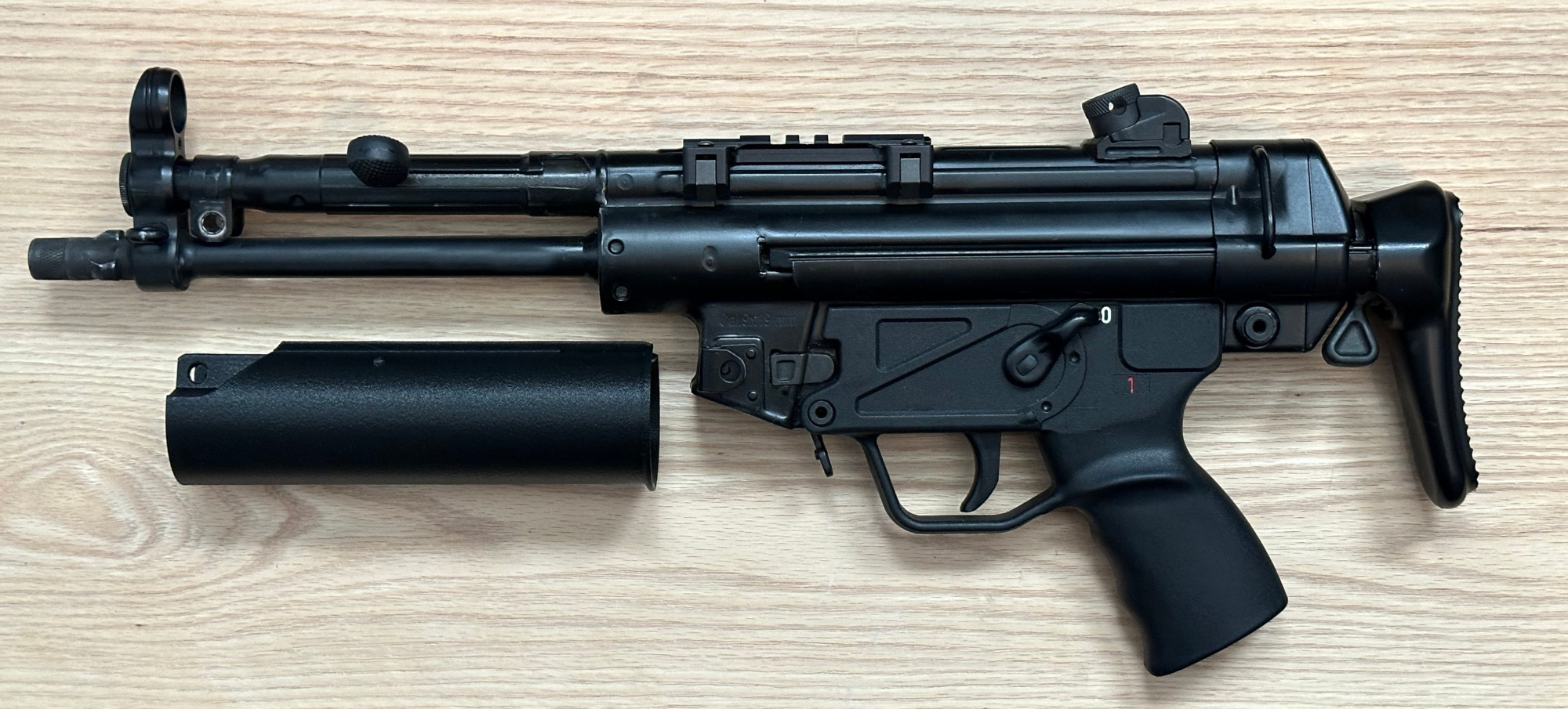 A picture of an MP5 without a handguard. The rear section of the BL-SD adapter is pictured next to it.