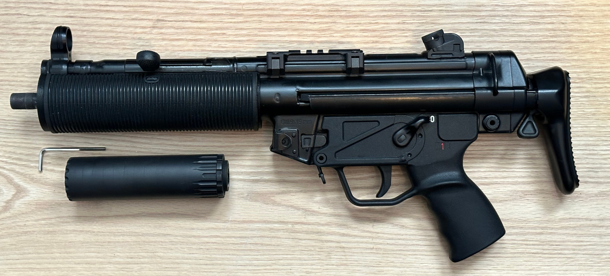 A picture of an MP5 wearing both the BL-SD adapter, and the German rubber shroud. The YHM R9 appears below.